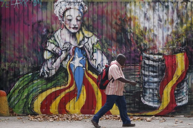 Grafite em Barcelona mostra mulher costurando a bandeira catal e flmula espanhola jogada no lixo