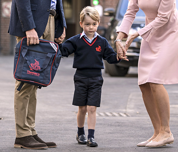 Britain's Prince George (C) accompanied by Britain's Prince William (L), Duke of Cambridge arrives for his first day of school at Thomas's school in Battersea where he is met by Helen Haslem (R) head of the lower school. / AFP PHOTO / POOL / RICHARD POHLE
