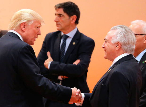 US President Donald Trump (L) shakes hands with Brazil's President Michel Temer at the beginning of the third working session of the G20 meeting in Hamburg, northern Germany, on July 8, 2017.?The G20 summit wraps up, with world leaders seeking to reach an agreement on a final joint statement despite divisions with US President Donald Trump over trade and climate change. / AFP PHOTO / AFP PHOTO AND POOL / LUDOVIC MARIN / SOLELY FOR REUTERS AND EPA
