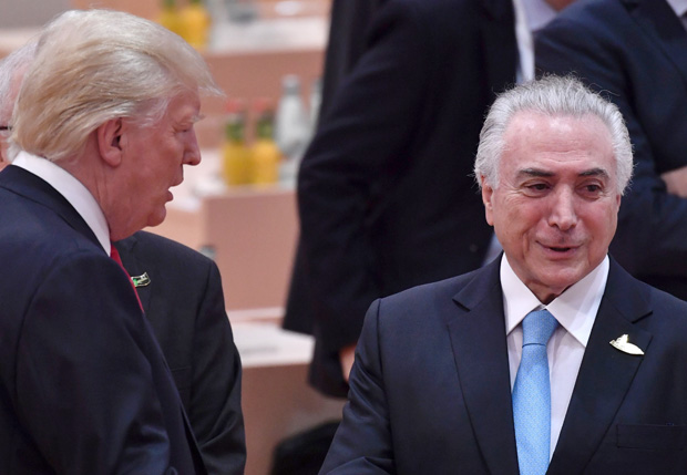 US President Donald Trump (L) and Brazil's President Michel Temer talk ahead the third working session "Partnership with Africa" on the second day of the G20 Summit in Hamburg, Germany, July 8, 2017. Leaders of the world's top economies gather from July 7 to 8, 2017 in Germany for likely the stormiest G20 summit in years, with disagreements ranging from wars to climate change and global trade. / AFP PHOTO / John MACDOUGALL