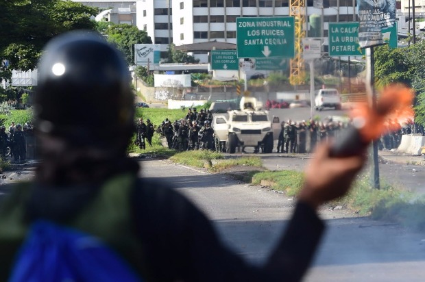 Manifestante preparar coquetel molotov para atirar contra foras de segurana em protesto em Caracas