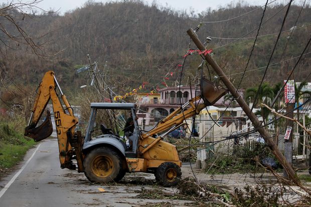 A worker uses a backhoe loader to remove damaged electrical installations from a street after the area was hit by Hurricane Maria in Yabucoa, Puerto Rico September 22, 2017. REUTERS/Carlos Garcia Rawlins ORG XMIT: VEN07