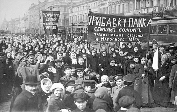 Protesto de trabalhadores durante a Revoluo de Fevereiro, em Petrogrado (So Petersburgo). A faixa da esquerda diz "Alimentem os filhos dos defensores da ptria" e o da direita diz "aumentem o pagamento das famlias dos soldados - defensores da liberdade e paz mundial" 