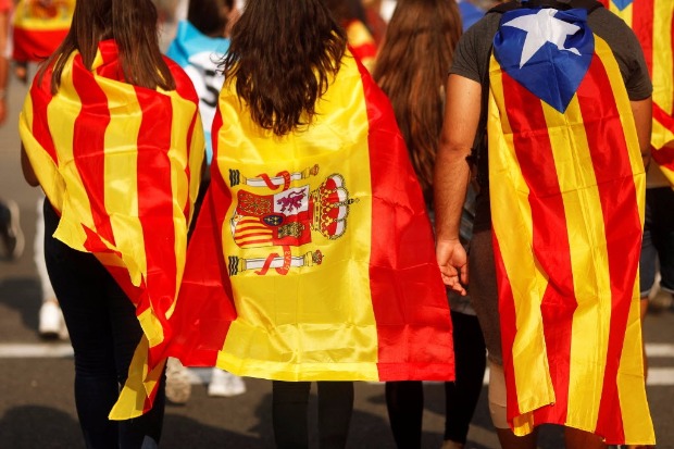Jovens com a atual bandeira catal, a espanhola e a separatista em protesto em Barcelona na tera (3)
