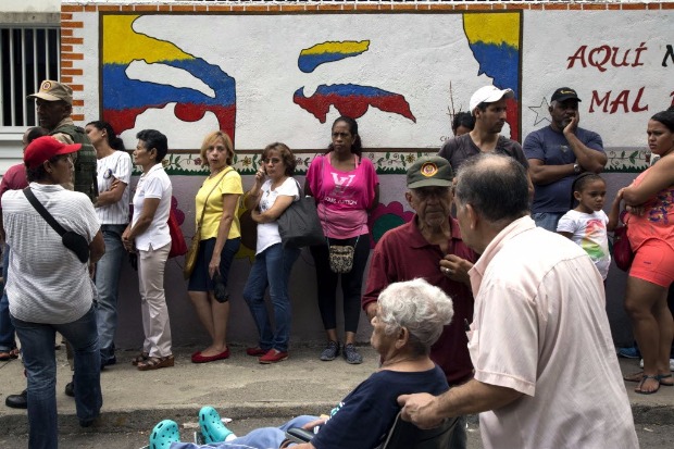 Eleitores esperam em fila do lado de fora de seo eleitoral no municpio de Sucre, na regio de Caracas
