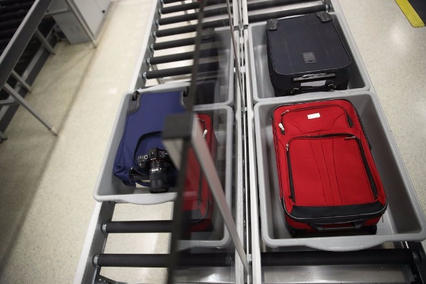 Viajantes passam bagagem de mão no embarque do aeroporto de Miami; EUA imporão novas inspeções