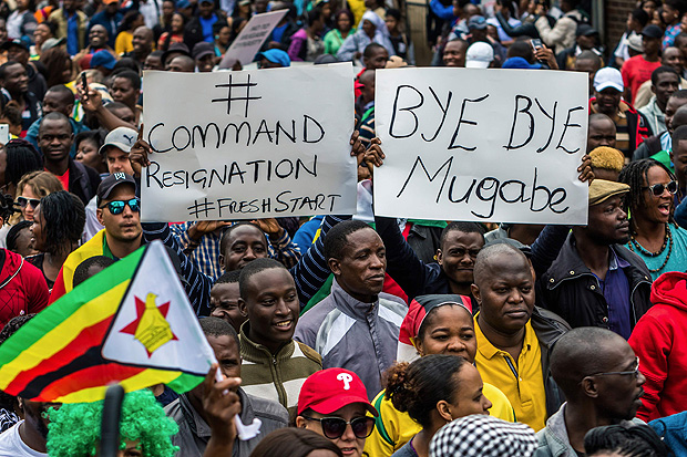 TOPSHOT - People carry placards during a demonstration demanding the resignation of Zimbabwe's president on November 18, 2017 in Harare. Zimbabwe was set for more political turmoil November 18 with protests planned as veterans of the independence war, activists and ruling party leaders called publicly for Zimbabwe's President to be forced from office. / AFP PHOTO / Jekesai NJIKIZANA