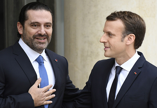 French President Emmanuel Macron (R) welcomes Lebanese Prime Minister Saad Hariri at the Elysee Presidential Palace on November 18, 2017 in Paris. Hariri is in Paris at the invitation of France's President who is attempting to help broker a solution to a political crisis that has raised fears over Lebanon's fragile democracy. / AFP PHOTO / BERTRAND GUAY