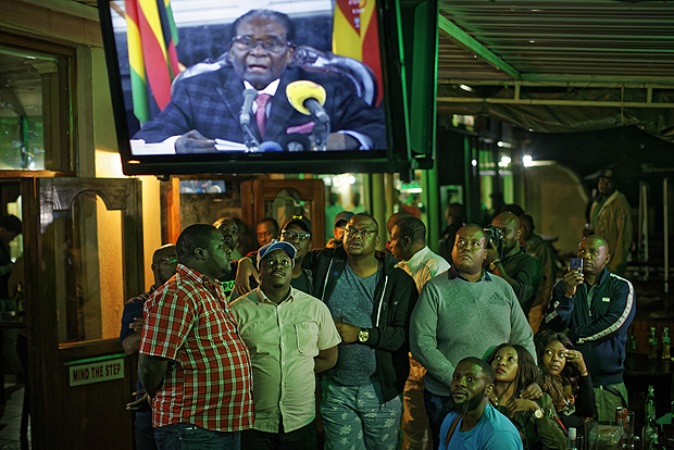 Zimbabweans watch a televised address to the nation by President Robert Mugabe at a bar in downtown Harare, Zimbabwe Sunday, Nov. 19, 2017. Zimbabwe's President Robert Mugabe has baffled the country by ending his address on national television without announcing his resignation. (AP Photo/Ben Curtis) ORG XMIT: ABC123