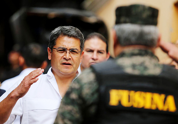 Handout picture released by the Honduran presidency press office showing President Juan Orlando Hernandez -who defies term limit seeking for re-election- saluting a member of the National Inter-institutional Security Force after shutting down Santa Barbara's prison during a visit to Santa Barbara, 220 kms north of Tegucigalpa, on November 23, 2017, ahead of next November 26 general elections. Voter opinion polls have been banned months ahead of elections, meaning no up-to-date survey results are available, though Hernandez states he holds a lead of 15 to 18 points over his closest rival Luiz Zelaya of the opposition Liberal Party. / AFP PHOTO / Honduras' Presidency / HO / RESTRICTED TO EDITORIAL USE - MANDATORY CREDIT 