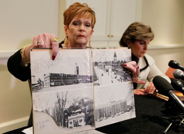Beverly Young Nelson (L) presents evidence at a news conference that Alabama U.S. Senate candidate Roy Moore signed her yearbook on December 08, 2017 in Atlanta. Beverly Young Nelson who accused Roy Moore of sexually assaulting her when she was 16 years old fights back against allegations that Roy Moore did not know her and did not sign her year book. / AFP PHOTO / TAMI CHAPPELL ORG XMIT: TLC103