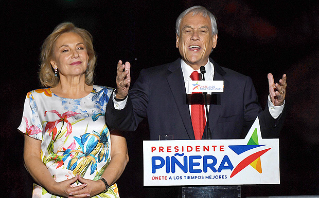 Chilean presidential candidate Sebastian Pinera (R), next to his wife Cecilia Morel, publicly celebrates his victory in Santiago after the runoff election on December 17, 2017. Conservative billionaire Sebastian Pinera will return as Chile's president, the election results show. His rival, leftist challenger Alejandro Guillier, a TV presenter turned senator who ran as an independent but was backed by outgoing center-left President Michelle Bachelet, recognized his defeat. / AFP PHOTO / Martin BERNETTI