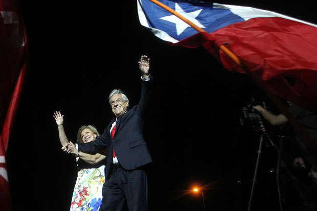 TOPSHOT - Chilean presidential candidate Sebastian Pinera (R) and his wife Cecilia Morel (L) celebrate his victory with family and supporters outside a hotel in Santiago after the runoff election on December 17, 2017. Conservative billionaire Sebastian Pinera will return as Chile's president, the election results show. His rival, leftist challenger Alejandro Guillier, a TV presenter turned senator who ran as an independent but was backed by outgoing center-left President Michelle Bachelet, recognized his defeat. / AFP PHOTO / CLAUDIO REYES ORG XMIT: CR01