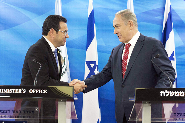 (FILES) This file picture taken on November 28, 2016 shows Guatemalan President Jimmy Morales (L) and Israeli Prime Minister Benjamin Netanyahu (R) shaking hands during a joint press conference after signing bilateral agreements at the Prime Minister's Office in Jerusalem. Guatemala's President Morales announced in his Twitter account on December 24, 2017 he gave instructions to his foreign minister that the country's embassy in Israel should be moved to Jerusalem. / AFP PHOTO / POOL / ABIR SULTAN
