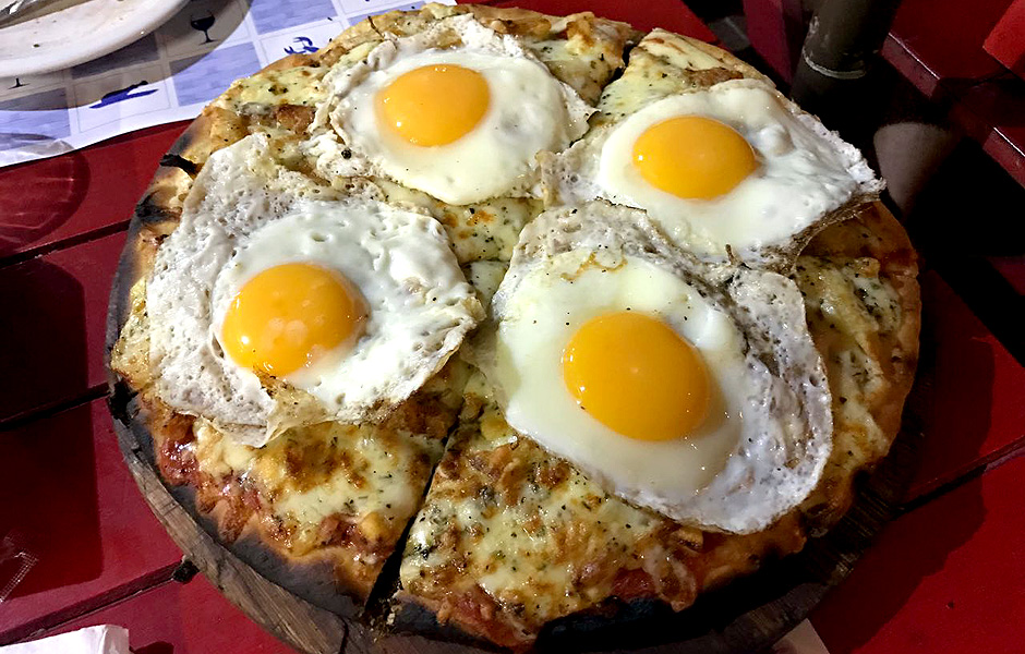 "Certamente a pizza mais estranha que j provei foi uma pizza denominada "Americana", com batata frita sendo um dos recheios e quatro ovos que chamavam muita ateno. Foi em Montevidu, no Uruguai". Foto enviada por Maurcio Duque, 46