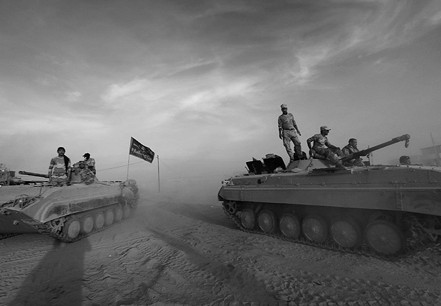 TOPSHOT - Members of the Iraqi forces stand on their BMP-1 infantry fighting vehicles as they hold a position in the village of Jarif, some 45 kilometres south of Mosul, on November 12, 2016, after retaking it from Islamic State (IS) group jihadists. / AFP PHOTO / SAFIN HAMED ORG XMIT: SH02