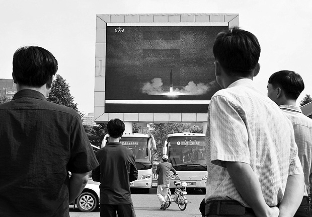 North Koreans watch a news report showing North Korea's Hwasong-12 intermediate-range ballistic missile launch on electronic screen at Pyongyang station in Pyongyang, North Korea, in this photo taken by Kyodo August 30, 2017. Mandatory credit Kyodo/via REUTERS ATTENTION EDITORS - THIS IMAGE HAS BEEN SUPPLIED BY A THIRD PARTY. MANDATORY CREDIT. JAPAN OUT. NO COMMERCIAL OR EDITORIAL SALES IN JAPAN. TPX IMAGES OF THE DAY