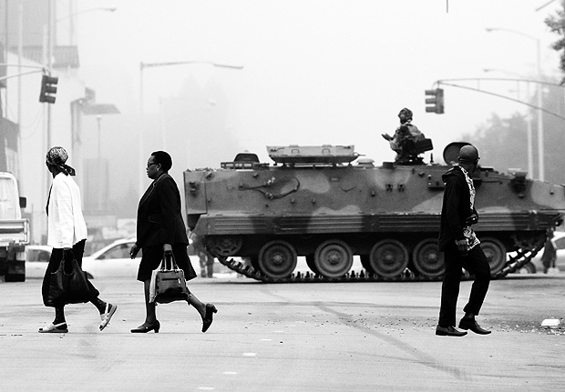 171115) -- HARARE, noviembre 15, 2017 (Xinhua) -- Personas caminan frente a un vehculo blindado en una calle en Harare, capital of Zimbabue, el 15 de noviembre de 2017. Varias explosiones de gran intensidad se oyeron a primeras horas del mircoles en el centro de la capital zimbabuense, Harare, dos das despus de que las fuerzas armadas de este pas africano amenazaran con "intervenir" para poner fin a la crisis poltica, pero los militares negaron haber lanzando un golpe de Estado. Los oficiales anunciaron en la televisin estatal que no han tomado el control del gobierno, pero "estn identificando a los criminales alrededor" del presidente zimbabuense, Robert Mugabe. (Xinhua/Philimon Bulawayo) (jg) (ah)