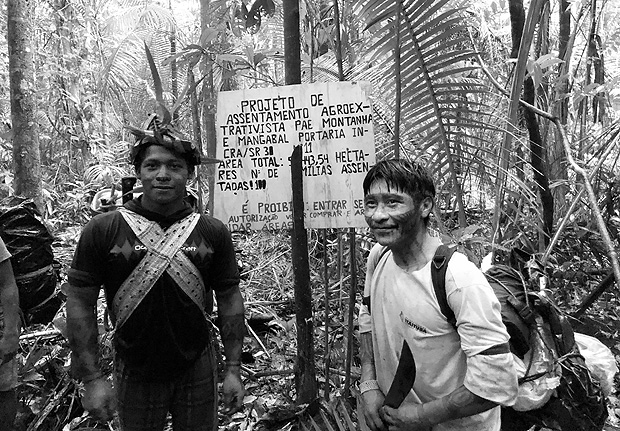 ITAITUBA, PA, 24-11-2017 - Ribeirinho e índio mundurucu diante de placa de autodemarcação do assentamento do Incra Montanha e Mangabal, em Itaituba (PA). ( Foto: Fabiano Maisonnave/Folhapress)