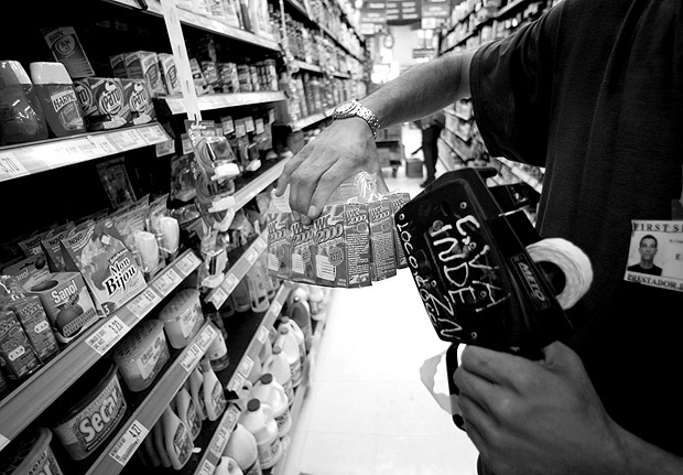 SO PAULO, SP, BRASIL, 04-12-2002: Funcionrio da rede de supermercados Po de Aucar remarca preos de produtos de limpeza, com mquina de etiquetar. Houve reajuste em relao aos preos da semana anterior. (Foto: Antnio Gaudrio/Folhapress, 0645)