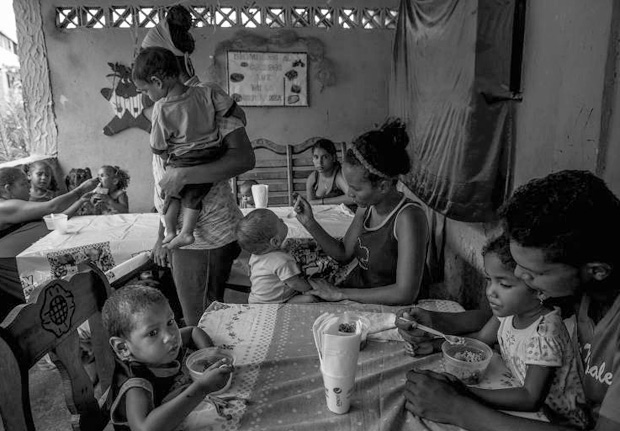 Crianas almoam em um 'sopo' comunitrio em uma favela de La Guaira, na Venezuela