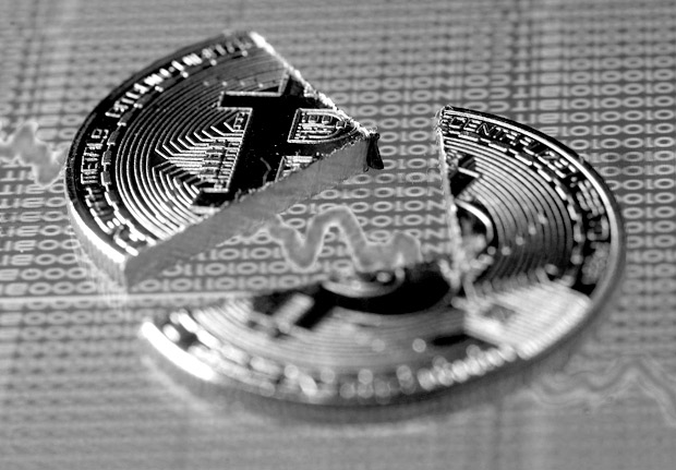 Broken representation of the Bitcoin virtual currency, placed on a monitor that displays stock graph and binary codes, are seen in this illustration picture, December 21, 2017. REUTERS/Dado Ruvic/Illustration ORG XMIT: DAD07
