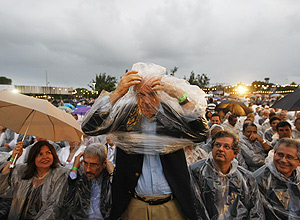 O ex-candidato a Presidência da República, José Serra veste capa de chuva durante a missa de Beatificação de Irmã Dulce
