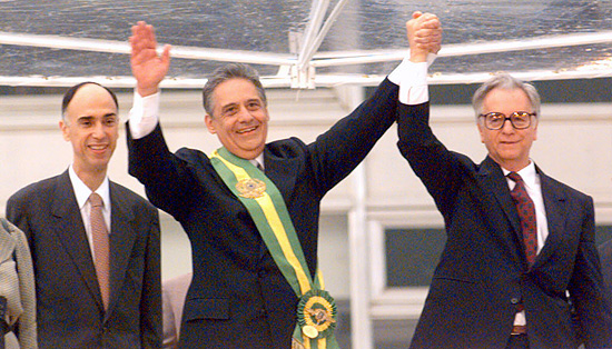 FHC e Itamar Franco levantam as mãos saudando o público em frente ao Palácio do Planalto durante a posse do primeiro