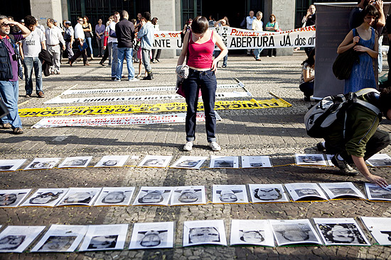 Mulher olha fotos de vtimas da ditadura militar em ato contra o coronel Ustra no centro de So Paulo