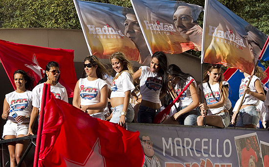 Meninas contratadas para campanha de candidato a vereador do PP seguram bandeiras de Haddad
