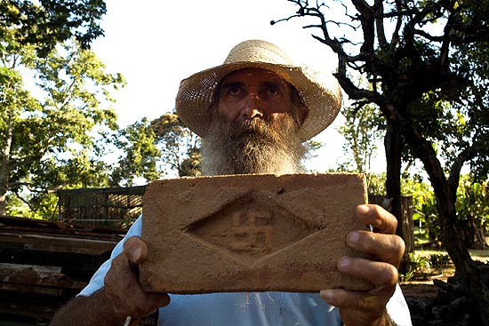 O tropeiro "Tatão" exibe tijolo com a suástica nazista usado na fazenda Cruzeiro do Sul, em Buri (SP)