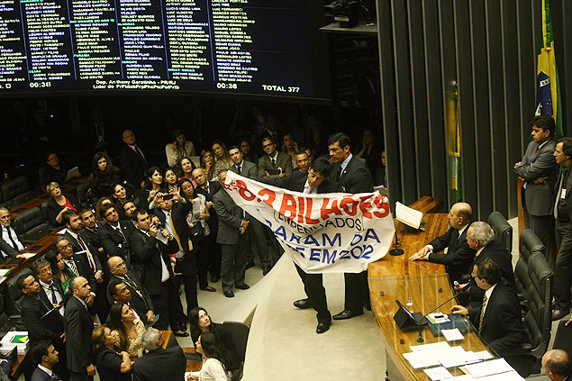 Deputado Toninho Pinheiro (PP-MG) abre faixa de protesto no plenário da Câmara dos Deputados durante a votação da MP dos Portos