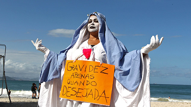 Vestida como Virgem Maria, participante da Marcha das Vadias protesta a favor do aborto