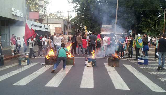 Manifestantes interditam rua no centro de Ribeiro Preto durante protesto; latas de lixo foram incendiadas e a PM acionada 