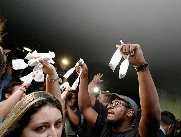 Manifestantes distribuem saquinhos com farinha, aludindo  cocana apreendido por policiais no helicptero dos Perrella