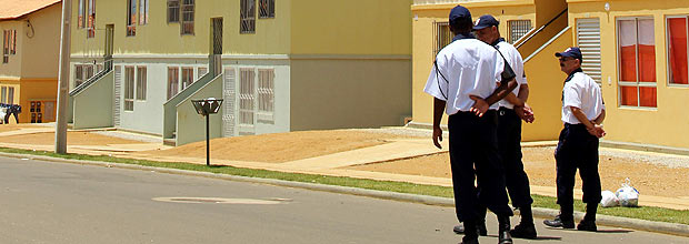 Seguranças caminham em frente a imóveis de condomínio Jequitibá, em Vitória da Conquista (BA)