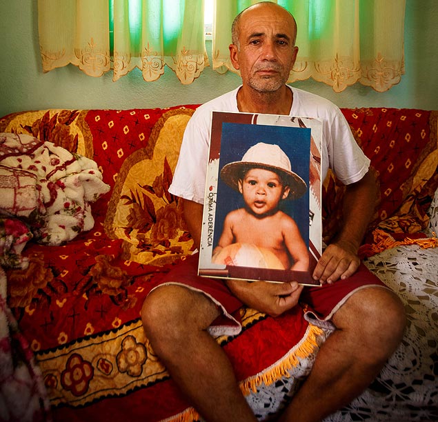 Jos Luiz Faria da Silva segura retrato do filho Maicon, morto durante operao policial em 1996
