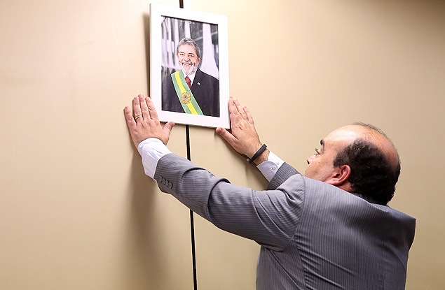 O lder do PR na Cmara, Bernardo Santana (MG) coloca o quadro do ex-presidente Lula na parede 