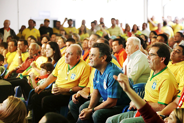 Acio Neves (PSDB) e a menina Dominique (ao fundo) assistem ao jogo entre as selees de Brasil e Camares