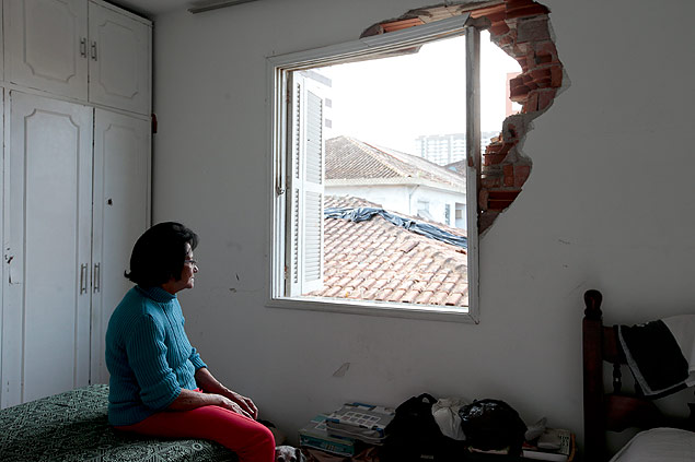 A aposentada Odessa da Silva Fonseca, 72, observa danos causados em seu apartamento pelo acidente