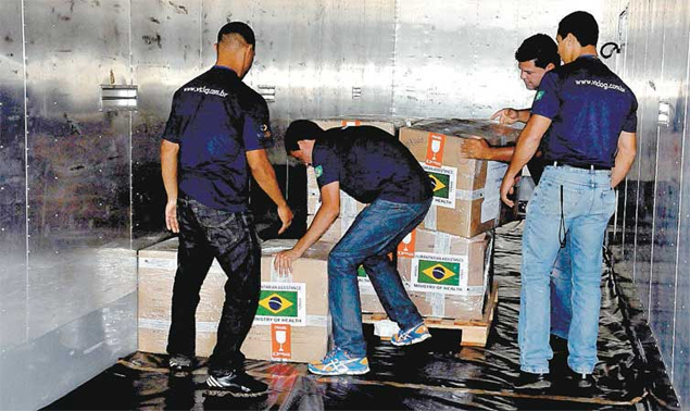 Funcionários carregam kits médicos do Brasil contra o ebola para serem enviados à África