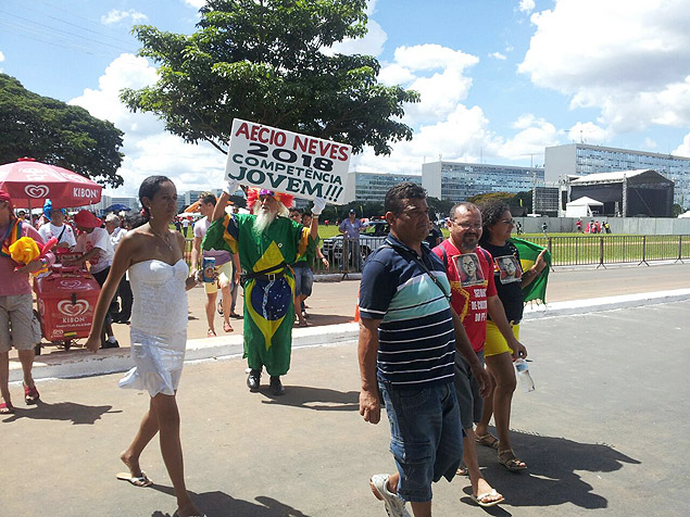 Em meio a petistas, homem carrega cartaz pró-Aécio Neves. Ele foi hostilizado pela militância do PT