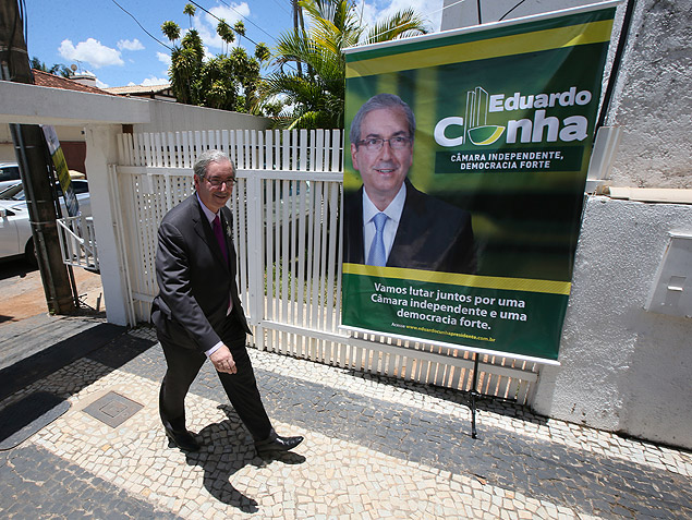 Eduardo Cunha passa em frente a um cartaz de sua campanha à presidência da Câmara