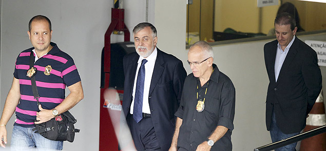 O ex-diretor da Petrobras Paulo Roberto Costa (o segundo à direita) é escoltado à Polícia Federal
