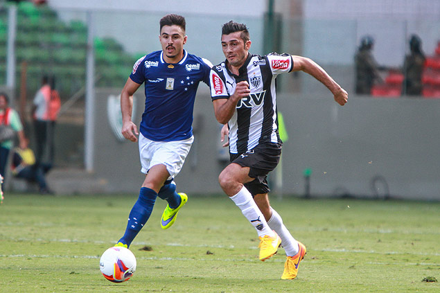  Jogadores de Cruzeiro e Atltico Mineiro disputam bola no clssico disputado neste domingo (12)