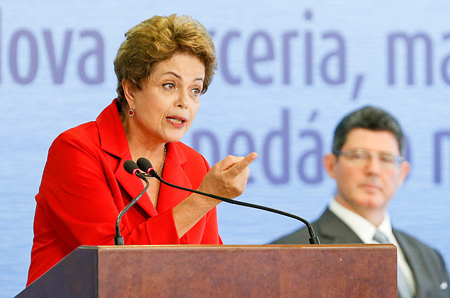 Dilma discursa no Planalto, sob os olhares do ministro Joaquim Levy (Fazenda), em evento