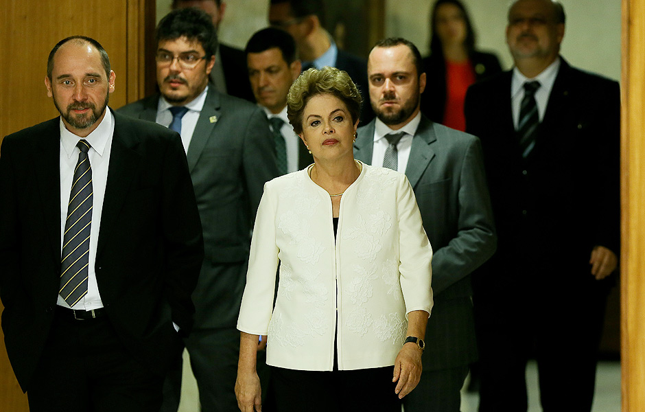 A presidente Dilma Rousseff, ao lado de ministros, momentos antes de fazer pronunciamento sobre acolhimento de pedido de Impeachment contra ela