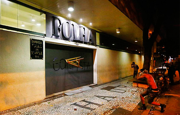 Os manifestantes contrários ao governo do presidente Temer e ao impeachment atiram um cavalete na fachada da seda da Folha de S.Paulo, na região central de cidade