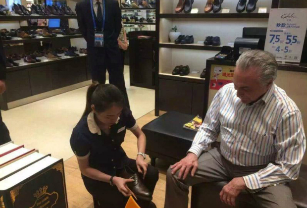 Brazilian President Michel Temer tries on a pair of shoes in a shopping mall in Hangzhou, east China's Zhejiang Province on September 3, 2016. [Reproduo/Twitter/@PDChina]