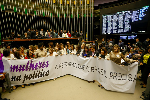 BRASILIA, DF, BRASIL, 16-06-2015, 19h00: Deputadas mulheres abrem uma faixa pedindo a aprovao da proposta que fixa cotas para eleio de mulheres no legislativo. A proposta est em anlise no mbito da reforma poltica que est sendo votada. O presidente da cmara dep. Eduardo Cunha (PMDB-RJ) preside a sesso. (Foto: Pedro Ladeira/Folhapress, PODER)